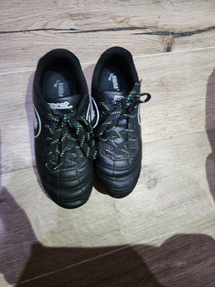 Size 13 Puma ProCat Speed Force FG Little Kids' soccer cleats in black and white.