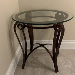 round glass end table with a bronze or dark metal frame 