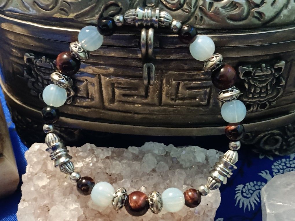 A combination of red. African tiger eye. Moonstone and silver Color fob accents. Size medium