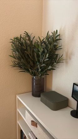 Faux olive branches in purple vase
