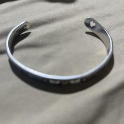 Shiny silver-tone cuff bracelet. Has a cute heart cutout on one end. Simple and stylish.