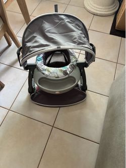 Fisher price baby outdoor chair with shade and okay center.