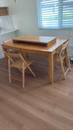 Dining room table with three chairs and middle insert