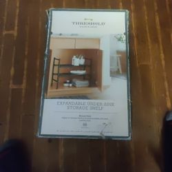 Threshold  under sink storage shelf