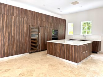 Custom modern Italian-style kitchen cabinetry with quartz countertops, Blum hardware, Franke sink, and faucet included