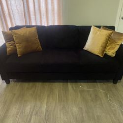 Black Sofa With Gold Pillows 