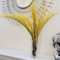 yellow artificial pampas grass arrangement in a clear glass vase.