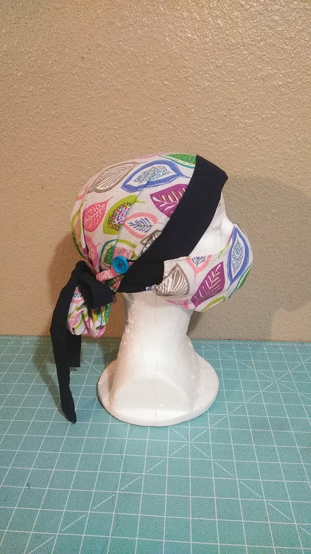 Two tone reversible surgical cap with buttons.