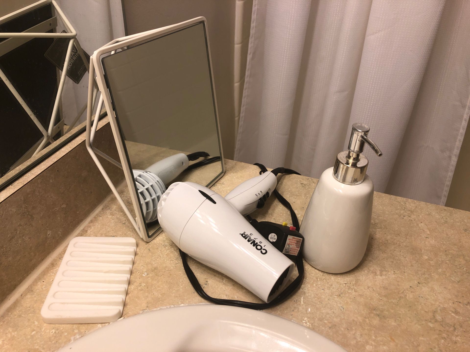 Bathroom items: Hair dryer, soap dispenser, mirror