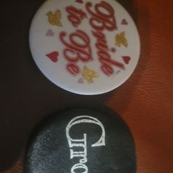 Buttons, two circular pins or badges, one white and one black, typically worn to celebrate a wedding or engagement events 