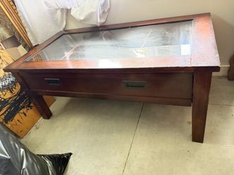 antiuqe coffee table with glass top and a drawer