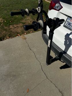 Thule Two Bike Hitch Rack for 2 inch hitch receiver.    Cons : needs to straps and one bolt / key to attach to hitch.