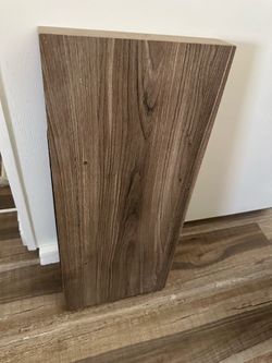Laminated wood floating shelf in a rich walnut finish.