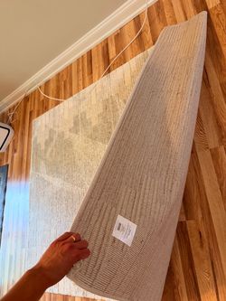 A cream rug with a subtle gray and beige pattern.