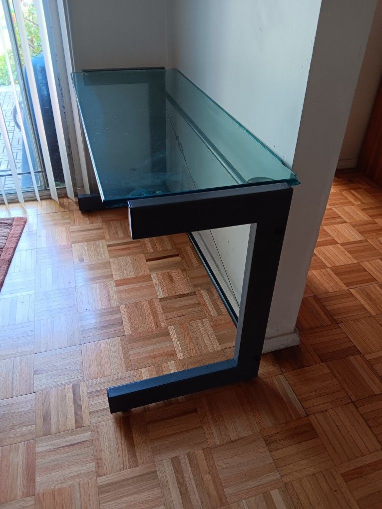 Modern glass top desk with metal frame.