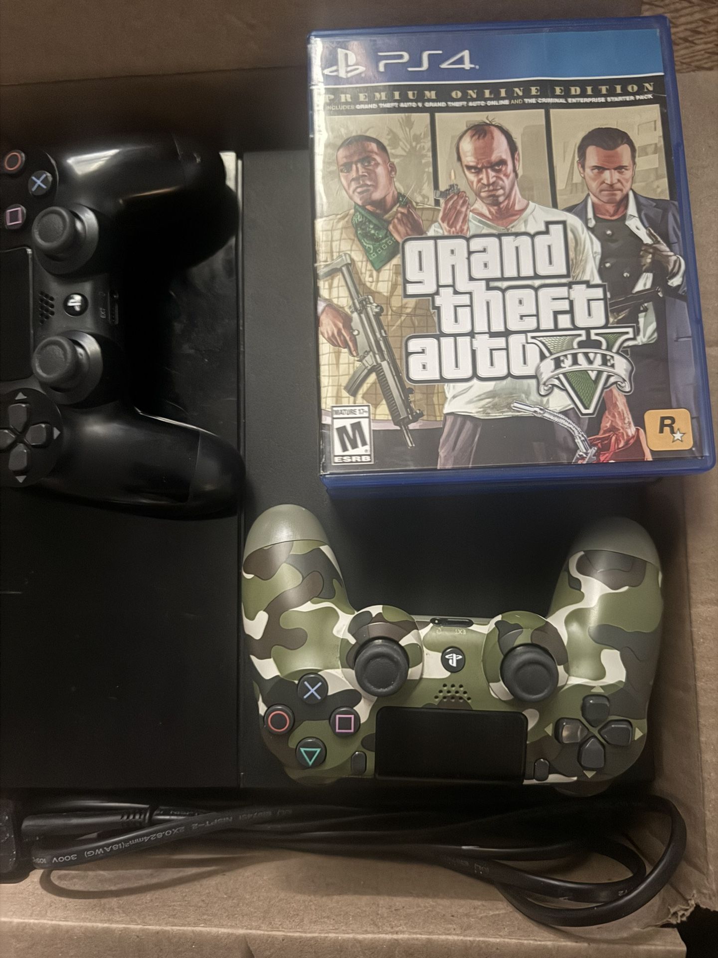 PS4 with power cable, 2 official PS controllers, GTA 5 and 3 other games.