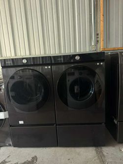 Set of Samsung Bespoke extra capacity washer and dryer with brushed black pedestals.