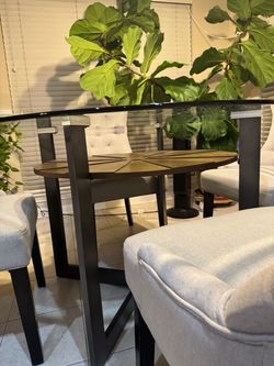 Sturdy, modern round glass dining table (48-inch diameter, 98% new, no scratches) plus four barrel-back dining chairs—$480 for the set.