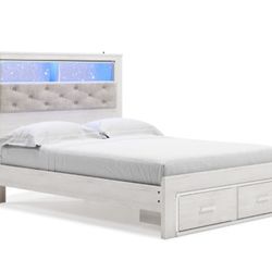 Altyra White LED Bookcase Upholstered Footboard Storage Platform Bedroom Set