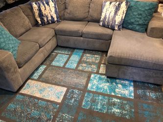 Gray sectional with rug and pillows