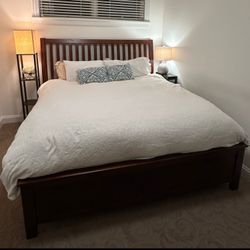 Queen-size wooden panel bed frame with a slatted headboard