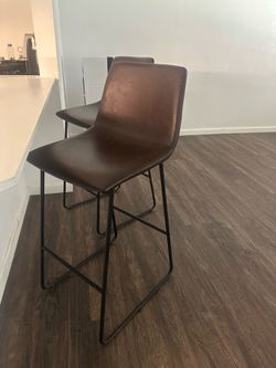 2 brown leather barstools￼