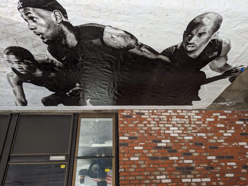 This is a 2012 Olympics stadium banner with Kobe Bryant LeBron James and Kevin Barrett