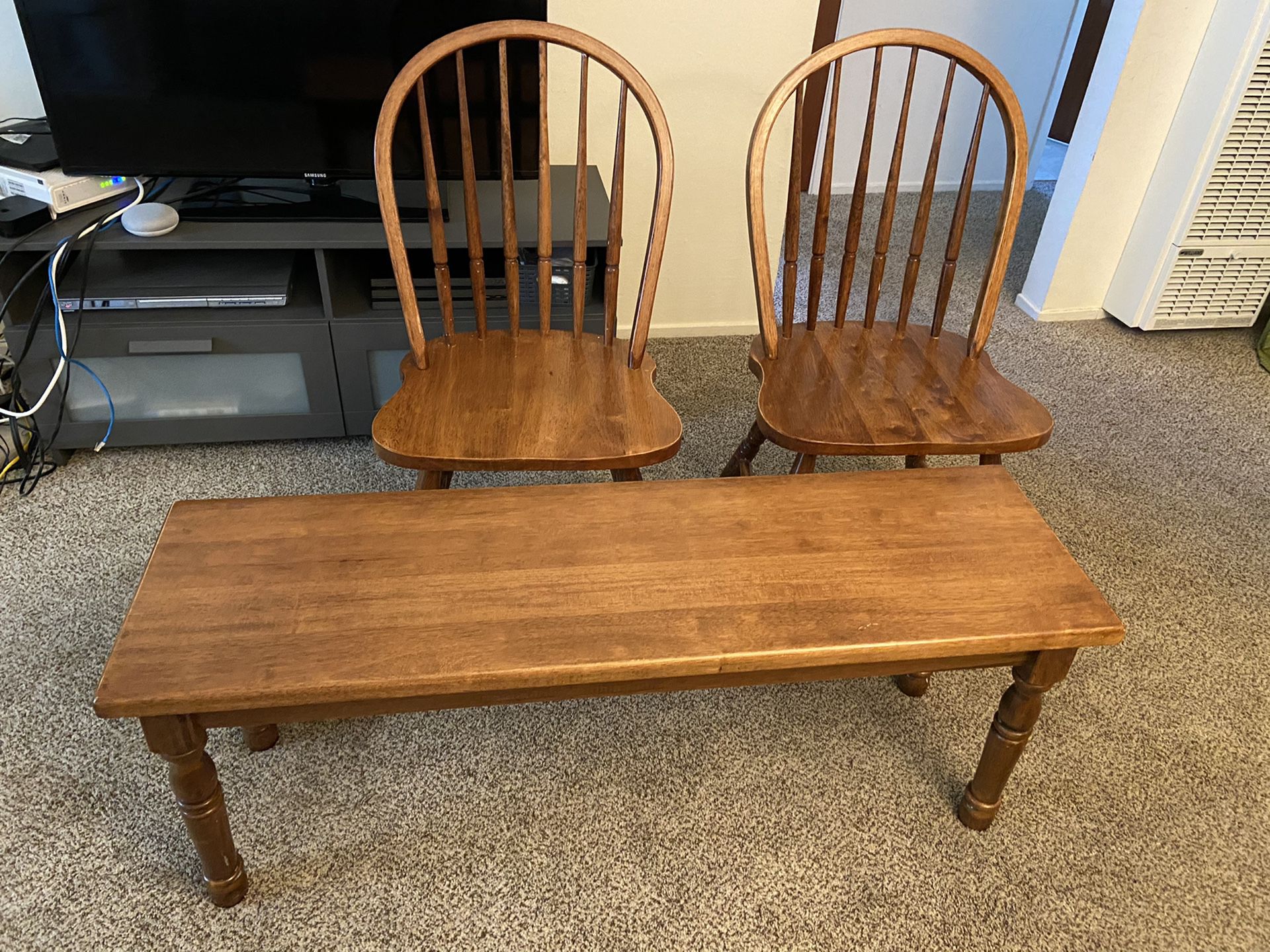 2 brown wooden chairs and a bench