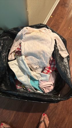 Black trash bag full of baby girl clothes