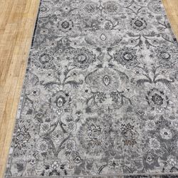 Beautiful 5’ x 8’ Delft Collection Area Rug in light and dark gray, beige, and cream.