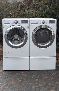 LG Washer And Electric Dryer Set On Pedestals.