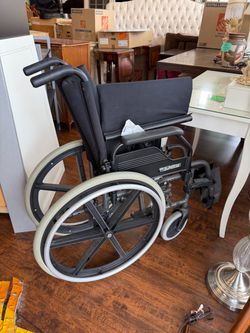Sunrise Medical manual wheelchair with large self-propel rear wheels, padded armrests, swing-away/removable footrests, wheel locks, and a folding fram