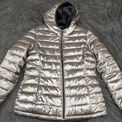 Andrew Marc women's silver puffer jacket with a black faux fur-lined hood