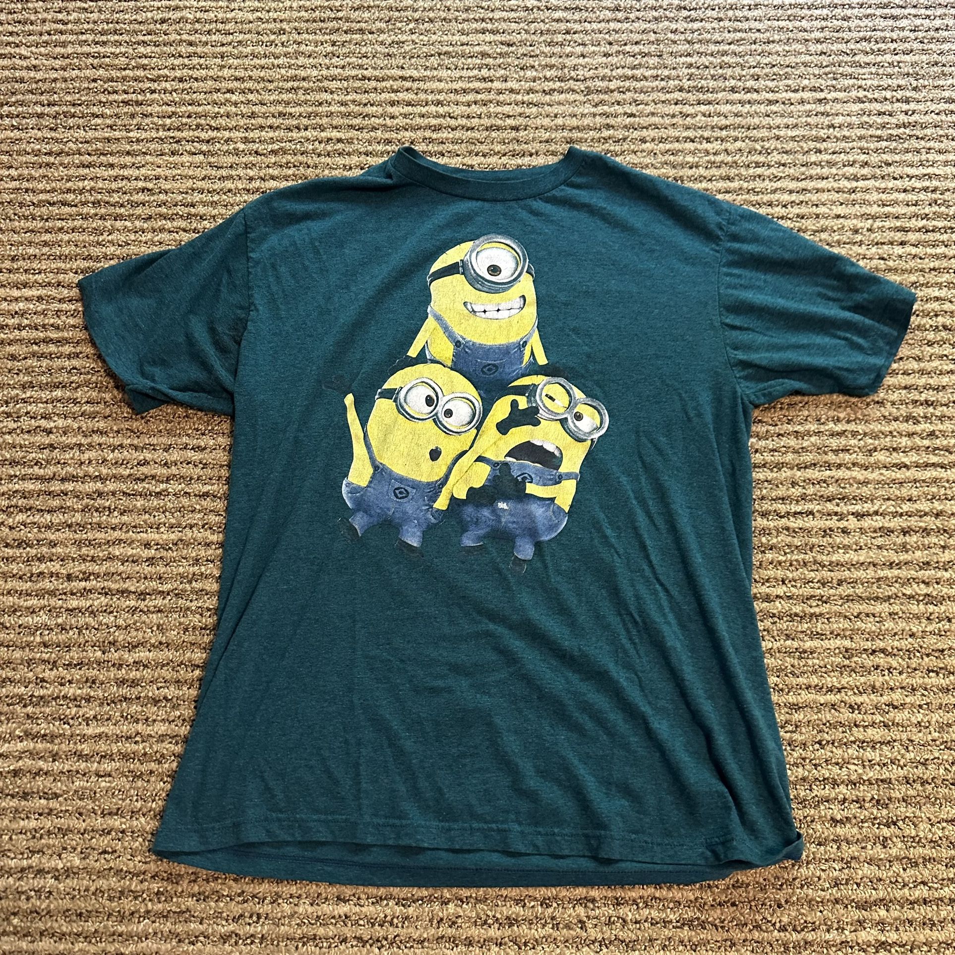 This Minions Despicable Me T-Shirt for men in size Large features a solid blue and green color with short sleeves and a crew neck. Made of a comfortab