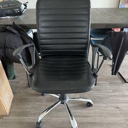 Black desk chair with armrests and wheels