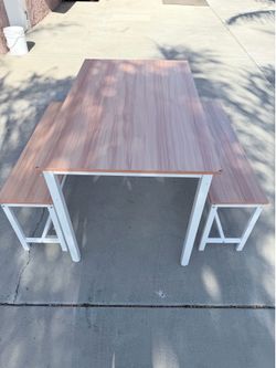Wood grain and white dining table with 2 benches some scratches on the end of the table