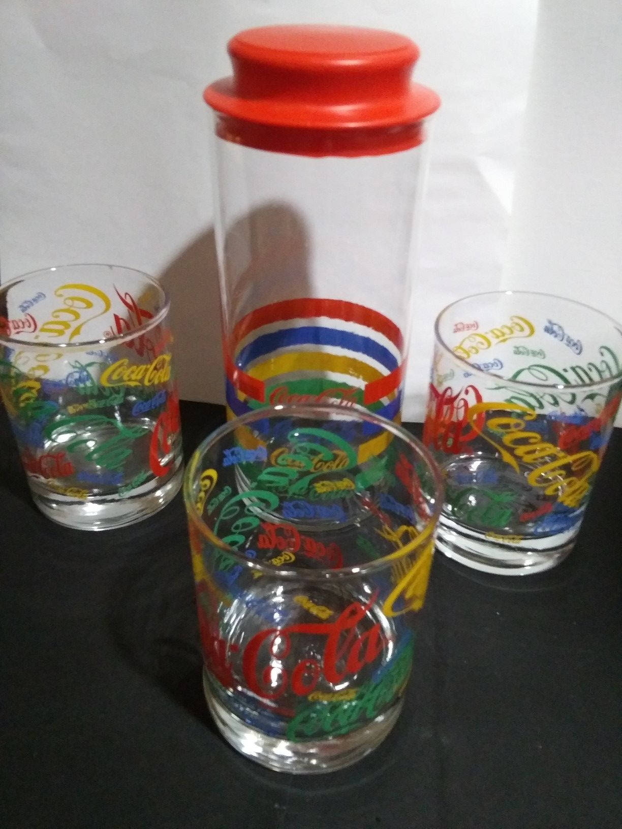 Lot of Coca-Cola glasses and straw caddy