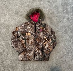 Realtree Xtra puffer jacket features a camouflage print with vibrant pink interior lining and a faux fur-trimmed hood
