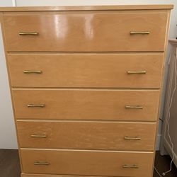 Vintage five-drawer dresser with brass hardware.