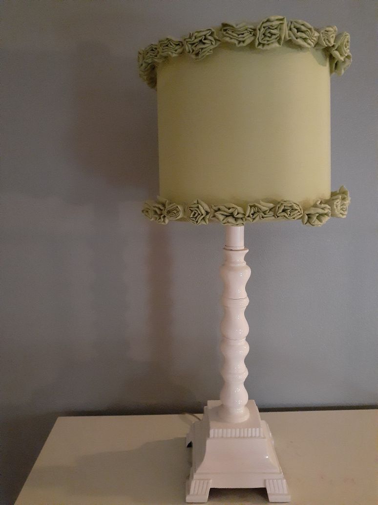White & Green Floral Lamp. White base 25in L with Light Mint Green Lamp Shade 10inD with Cloth Flowers on top & bottom trim