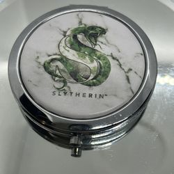 REGISTERED HARRY POTTER SLYTHERIN HOUSE CREST ROUND COMPACT MIRROR  2 7/8"  This compact mirror features the iconic Slytherin house crest from the Har