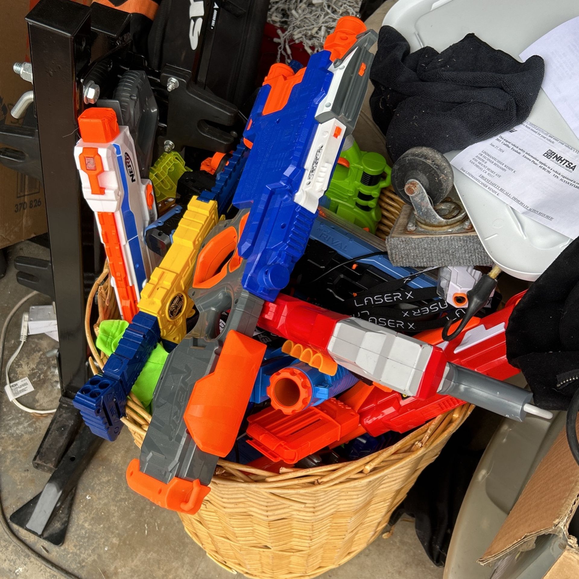 A whole basket of big nerf guns and lazer tag guns