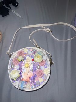 Decorated purple purse and shoulder bag. Both have cute designs and charms.