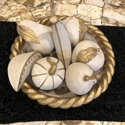 Braided gold-finished bowl containing white and gold fruit decorative centerpiece