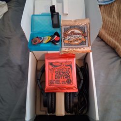 Headphones  2 sets of guitar strings.\n A box of pics and  A tuner.