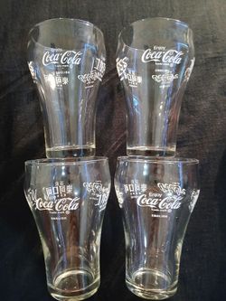 4 Coca-Cola cups that read Coca-Cola in Japanese/Chinese/Arabic/Hebrew,  on each glass