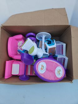 Box full of plastic doll house furniture