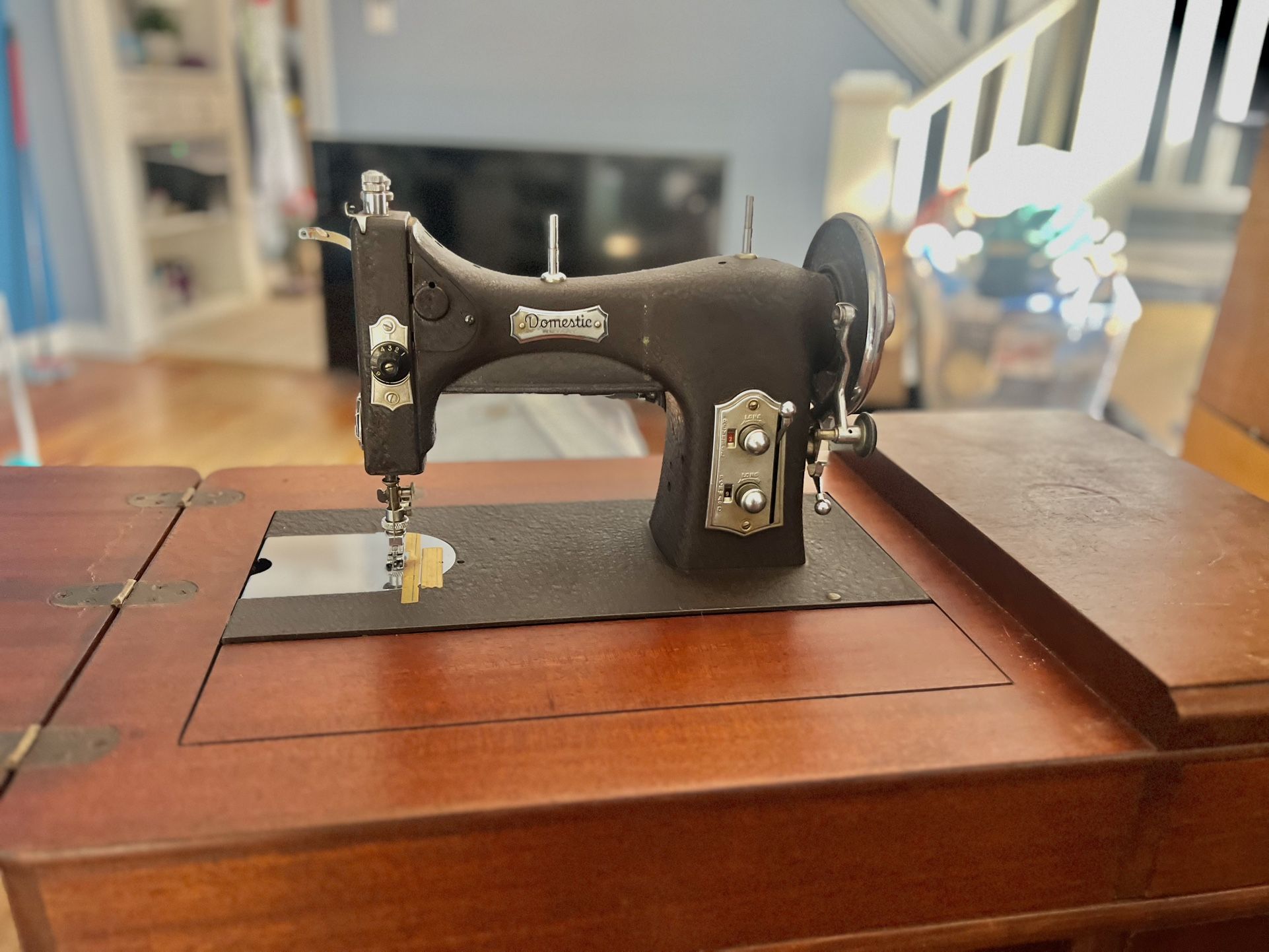 Deluxe No. 153 "Domestic" brand rotary electric sewing machine, with wood cabinet.