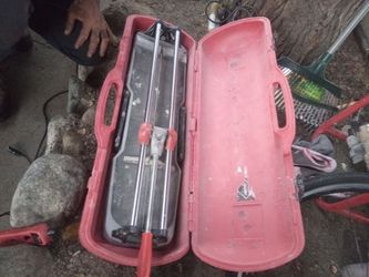The image shows a RUBI manual tile snap cutter inside its red plastic carrying case, which resembles models from the Rubi Speed or Fast series designe