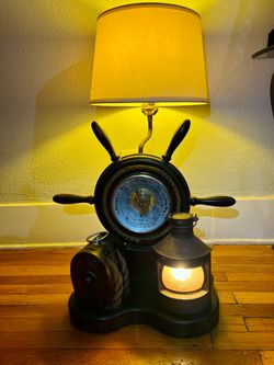 vintage nautical table lamp featuring a ship's wheel, a central barometer, a rope block and tackle, and a ship's lantern base